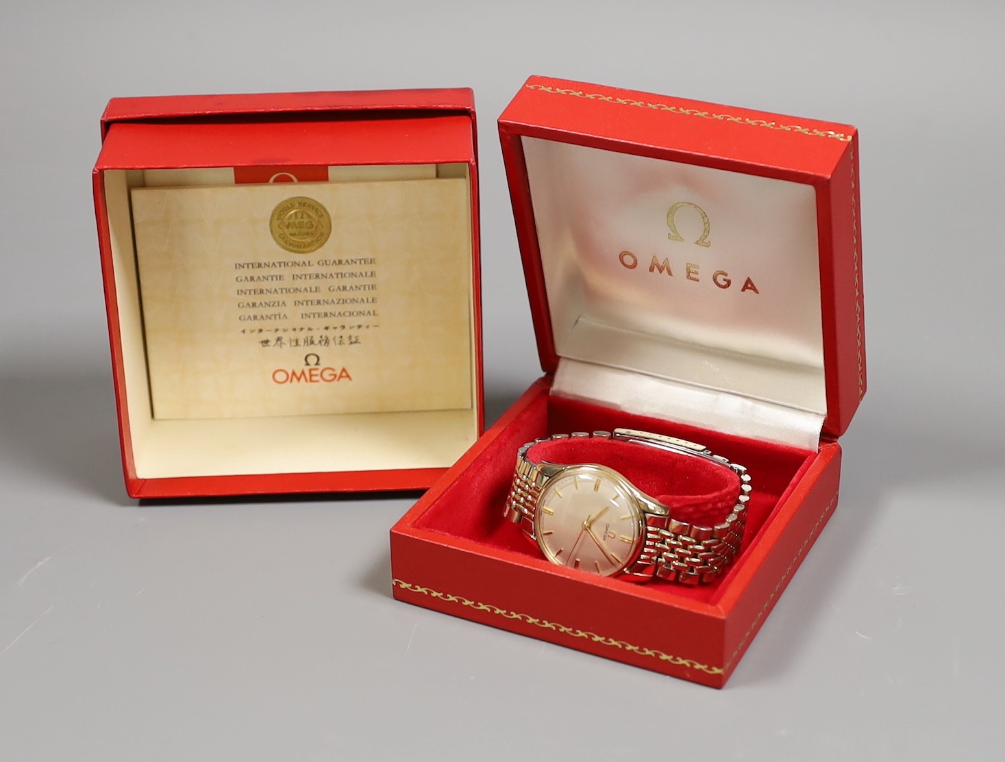 A gentleman's 9ct gold Omega manual wind wrist watch, on an Omega steel and gold plated bracelet, with box and pamphlets.